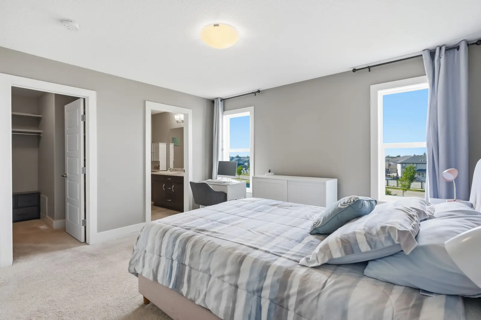 Primary bedroom with walk-in closet and ensuite doors