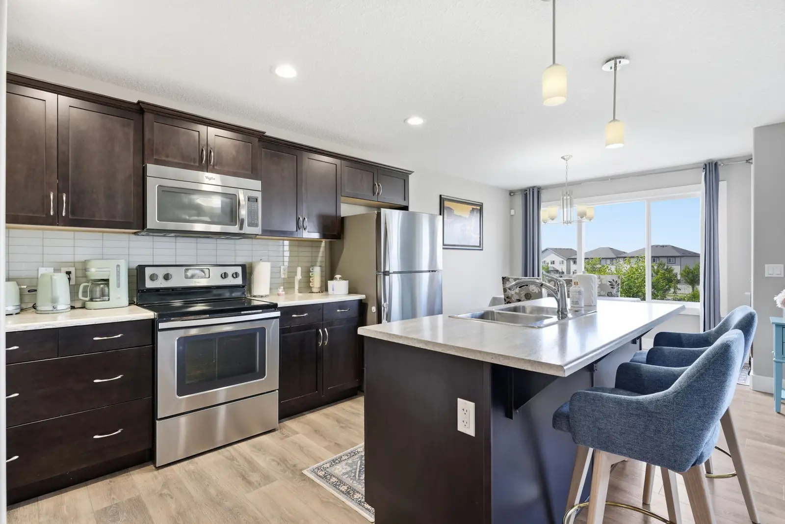 Kitchen with centre island, espresso Kitchen Craft cabinetry and stainless appliances